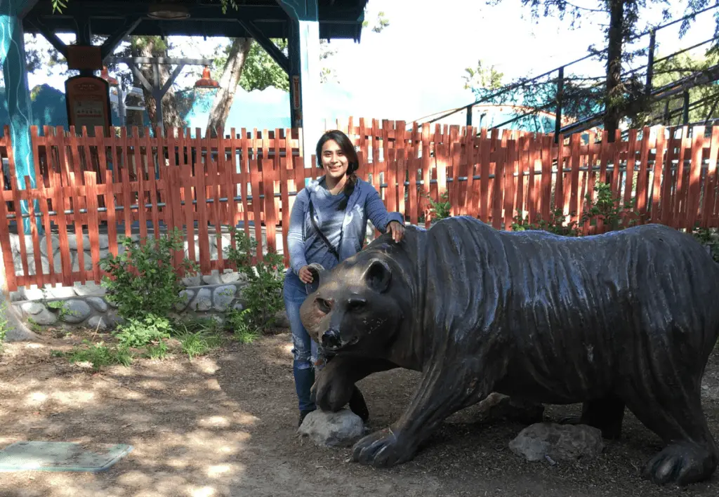 My wife at the Boise Zoo standing next to a bear statue.